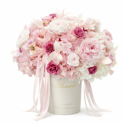 LULU ROSÉE Detailed View of Blush Hydrangea Rose Garden Bucket, Mixed Pink Preserved Roses and Hydrangeas on a white background