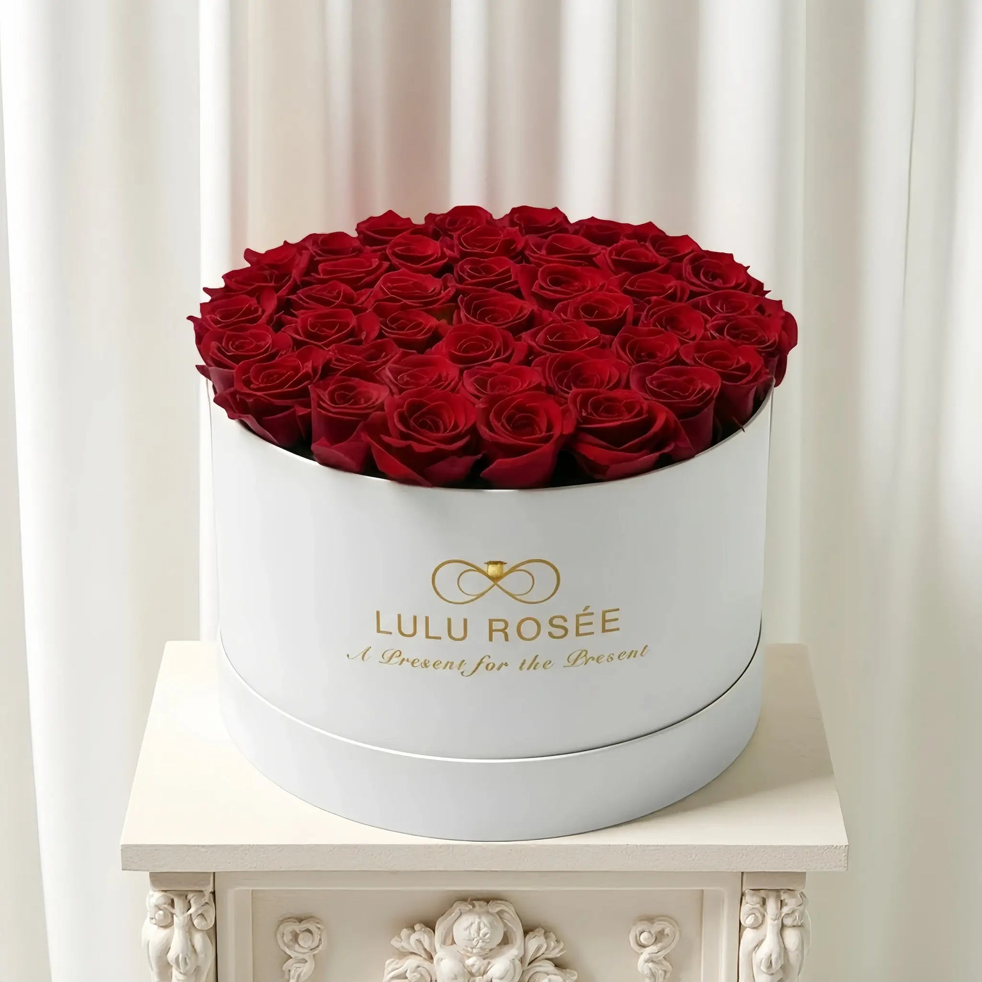 LULU ROSÉE extra large round box red roses white classic box on a gift table