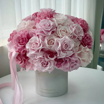 LULU ROSÉE Monochrome Pink Rose Garden Bucket, Preserved Rose Arrangement in Front of Sheer Curtains
