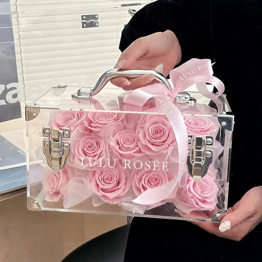 LULU ROSÉE Petite Eternal Acrylic Handbag Rose Box, small transparent acrylic handbag-shaped gift box filled with blush pink preserved roses decorated with pink satin bow, full front display shot, customizable flower color options, mini luxury everlasting floral souvenir for birthday, anniversary & romantic gift giving